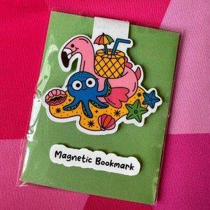 May include: A green cardstock bookmark with a pink flamingo, blue octopus, and pineapple design. The bookmark has a magnetic strip and the text "Magnetic Bookmark" printed on the front.