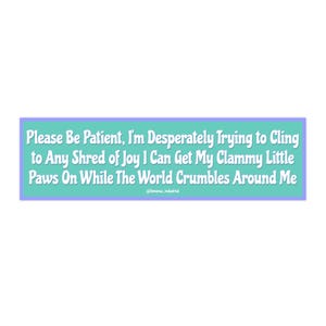 Op de afbeelding: Een rechthoekige sticker met een turquoise achtergrond en een lichtpaarse rand. De sticker heeft witte tekst: "Please Be Patient, I'm Desperately Trying to Cling to Any Shred of Joy I Can Get My Clammy Little Paws On While The World Crumbles Around Me."