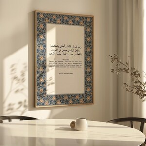 May include: Framed artwork with Arabic script and English translation. The frame has a decorative blue and gold floral pattern. The text includes the phrase "My Lord" and the title "Surah Ash-Shu'ara". The artwork is displayed on a wall.