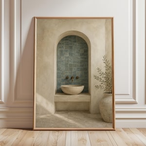 May include: Framed art print featuring a serene bathroom scene. The artwork depicts a stone sink, brass fixtures, and teal tile within an arched alcove. A vase with greenery is on the right. The frame is a warm brown color.