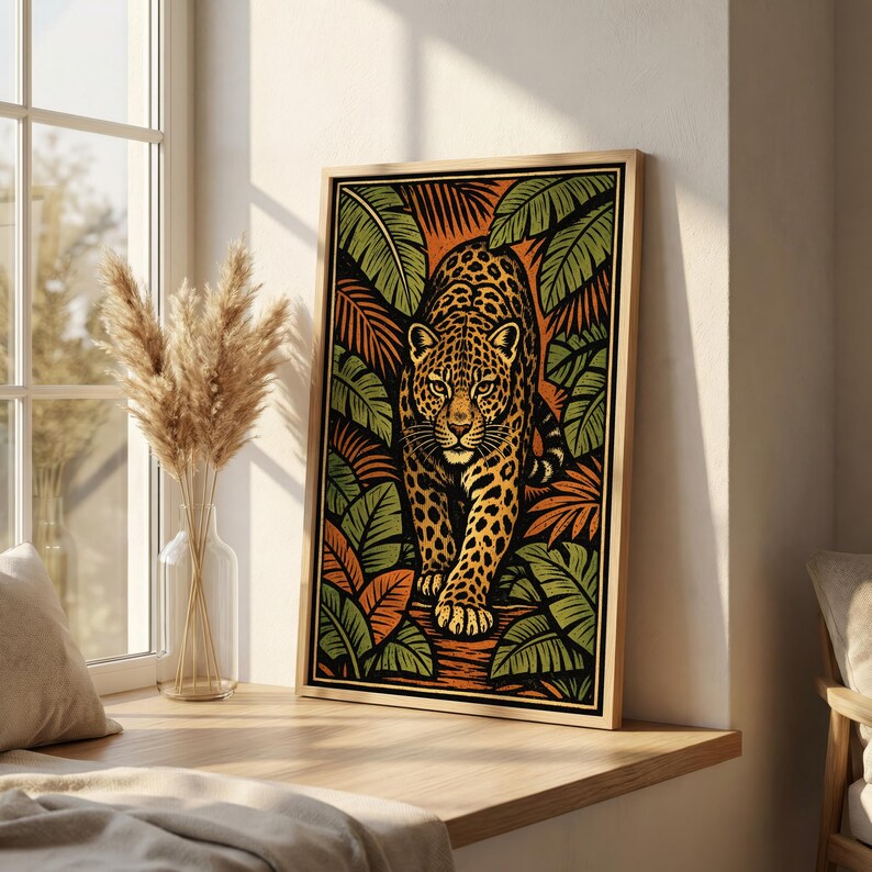 May include: A framed art print featuring a stylized jaguar walking forward. The artwork has a jungle theme, with the jaguar surrounded by green and orange foliage. The jaguar has a spotted coat and is set against a black background.