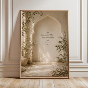 May include: A framed print featuring an arched doorway design with the text "So remember Me; I will remember you." The artwork has a neutral color palette with beige and brown tones, and includes decorative plants in vases. The frame is a light brown color.