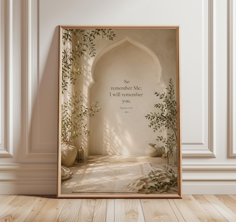 May include: A framed print featuring an arched doorway design with the text "So remember Me; I will remember you." The artwork has a neutral color palette with beige and brown tones, and includes decorative plants in vases. The frame is a light brown color.