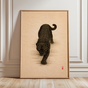 May include: A framed art print showing a black panther in a walking pose. The panther is rendered with detailed shading on a beige background. The artwork is presented in a simple wooden frame, adding a touch of elegance to the piece.