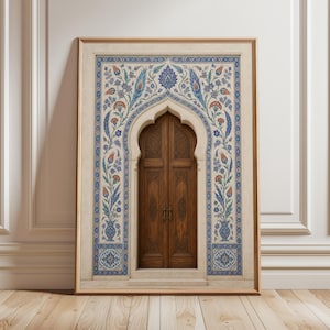 Puede incluir: Impresi&oacute;n enmarcada de una puerta de madera detallada con una entrada arqueada. La puerta est&aacute; dentro de un panel decorativo con patrones florales azules, naranjas y blancos. El marco es dorado y la impresi&oacute;n se muestra en un suelo de madera.