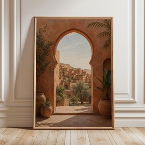 May include: Framed print of an arched doorway revealing a sunlit village. The artwork uses warm terracotta hues, with potted plants and a blue sky. The scene creates a sense of calm and travel, reminiscent of a Mediterranean vista.