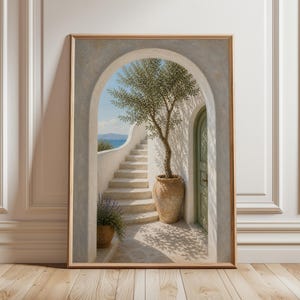 Könnte beinhalten: Gerahmter Kunstdruck mit einer mediterranen Szene. Eine weiße Treppe führt zu einem blauen Himmel und Meerblick, eingerahmt von einem Torbogen. Ein Olivenbaum in einem Terrakottatopf wirft Schatten auf die Steinterrasse. Eine grüne Tür ist sichtbar.