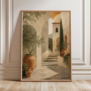 Pode incluir: Uma impressão de arte de parede emoldurada retratando um pátio mediterrâneo com arcos de pedra, vasos de terracota com oliveiras, um cipreste alto e degraus de pedra que levam a um edifício com telhado de telhas vermelhas em tons bege.