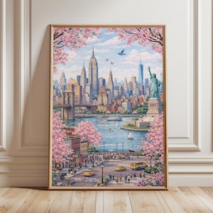 Op de afbeelding: Een ingelijste kunstdruk met een levendige sc&egrave;ne van New York City. Het kunstwerk toont de skyline, inclusief het Empire State Building en het Vrijheidsbeeld, omlijst door bloeiende roze kersenbloesems. Gele taxi's en een brug zijn ook zichtbaar.