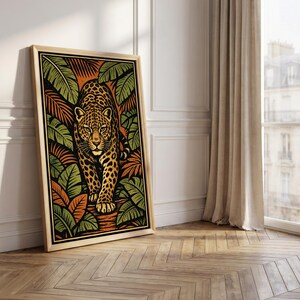 May include: A framed art print featuring a stylized leopard walking forward. The artwork uses a palette of orange, green, and black, with the leopard's spots and the surrounding foliage adding detail. The frame is a light wood color.