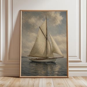 May include: A framed vintage-style painting of a sailboat on the water under a cloudy sky. The sailboat has white sails and a wooden hull. The artwork is in a wooden frame and is displayed against a white wall.