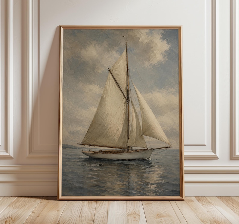 May include: A framed vintage-style painting of a sailboat on the water under a cloudy sky. The sailboat has white sails and a wooden hull. The artwork is in a wooden frame and is displayed against a white wall.