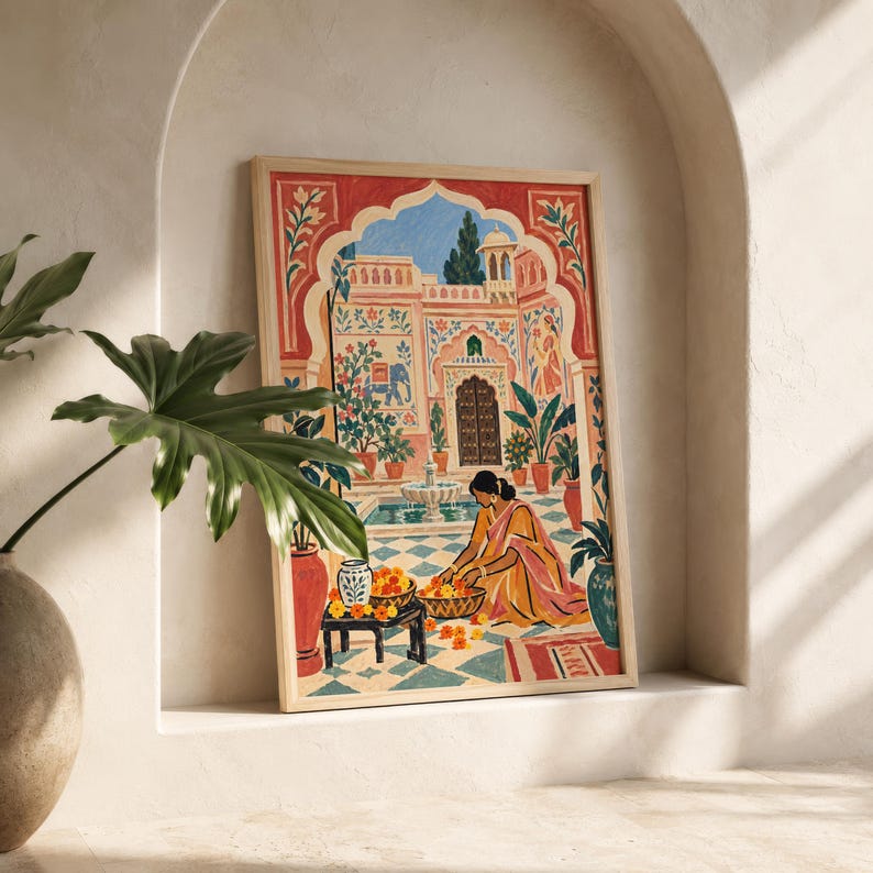 May include: A framed rectangular art print featuring a colorful illustration of a person in a yellow garment kneeling on a tiled patio, arranging orange flowers in baskets. The scene includes a fountain, potted plants, and an arched building.