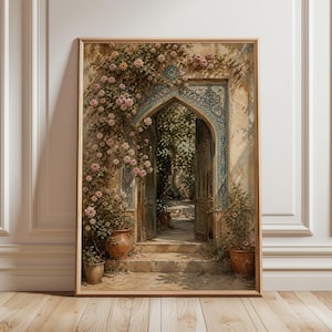 May include: A framed art print shows an open doorway with an arched top, decorated with detailed blue and white tiles. The doorway leads to a sunlit garden, with climbing roses and potted plants. The artwork is in a wooden frame.