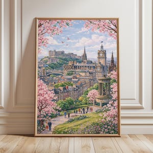 May include: Framed print of Edinburgh, Scotland, featuring a cityscape with a castle on a hill, a clock tower, and a monument. Pink cherry blossoms frame the top and sides of the image. People are walking on a path in the foreground.