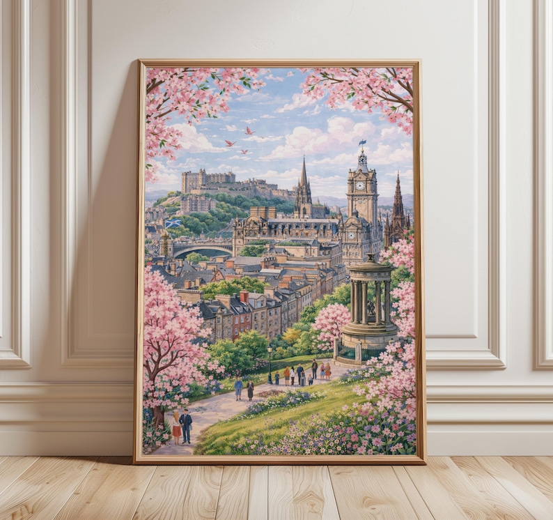 May include: Framed print of Edinburgh, Scotland, featuring a cityscape with a castle on a hill, a clock tower, and a monument. Pink cherry blossoms frame the top and sides of the image. People are walking on a path in the foreground.