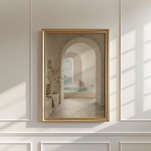 May include: A framed print shows a tranquil interior with arched doorways leading to a pool with a sea view. The artwork features a neutral colour palette with a gold frame, a vase with greenery, and a towel.