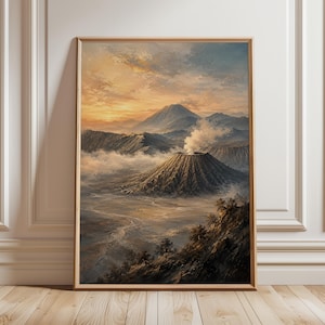 以下が含まれることがあります： 日の出の火山風景を描いた額装済みの縦型ウォールアートプリント。中央には噴煙を上げる火山があり、険しい山々、霧、そして黄金色と青色の空の下に広がる広大な谷底が描かれています。