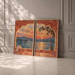 May include: Two rectangular framed wall art prints featuring a split landscape painting. The scene depicts a sunset over a lake viewed through a stone archway, with a person sitting on a ledge in each panel and red flowers hanging above.