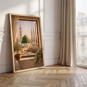 May include: A framed print of a Middle Eastern cityscape, featuring a green-domed structure and minarets, viewed through a window. The artwork is set against a neutral wall with a wooden floor, and a potted plant is visible.