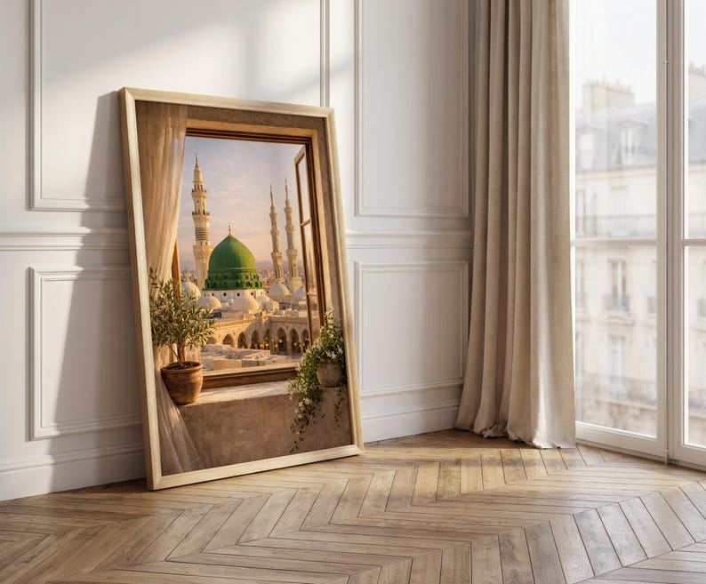 May include: A framed print of a Middle Eastern cityscape, featuring a green-domed structure and minarets, viewed through a window. The artwork is set against a neutral wall with a wooden floor, and a potted plant is visible.