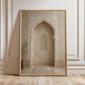 Puede incluir: Impresión artística enmarcada que presenta una alcoba arqueada con una pequeña ventana y una alfombra decorativa. La obra de arte tiene una paleta de colores neutros con tonos beige y marrón. Un jarrón con una planta está a la izquierda. El marco es de madera.
