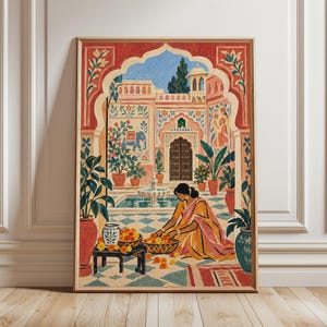 May include: A framed art print depicting a courtyard scene with a person in a yellow and pink garment arranging orange flowers in baskets. The setting features a fountain, potted plants, an arched doorway, and a blue elephant wall mural.