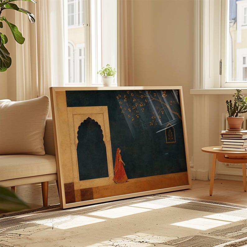 May include: A rectangular framed wall art print featuring a dark teal background with a golden archway, a person in a vibrant orange garment walking, and a tree with golden leaves. The artwork is displayed in a light-coloured wooden frame.