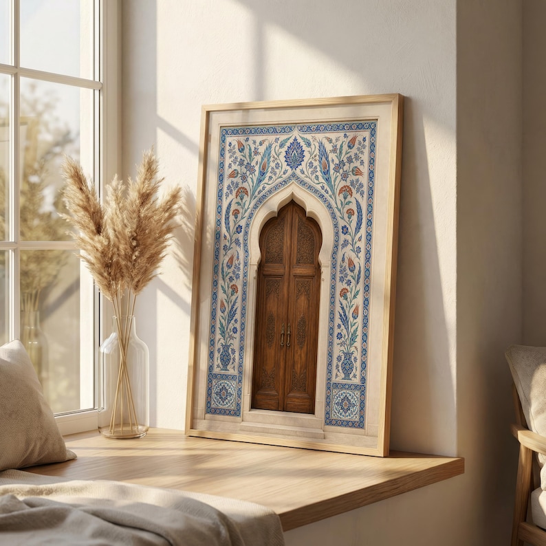 Puede incluir: Una impresi&oacute;n enmarcada que presenta una puerta de madera dentro de un arco, adornada con intrincados patrones florales azules, naranjas y blancos. El marco es de madera clara y la impresi&oacute;n se exhibe en un alf&eacute;izar. Una obra de arte decorativa.