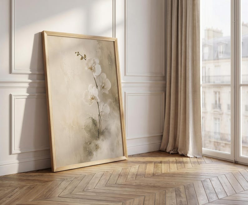 K&ouml;nnte beinhalten: Ein gerahmter vertikaler Wandkunstdruck, der einen zarten wei&szlig;en Orchideenzweig mit mehreren Bl&uuml;ten vor einem weichen, neutralen, abstrakt bemalten Hintergrund mit ged&auml;mpften beigen und salbeigr&uuml;nen Pinselstrichen in einem hellen Holzrahmen zeigt.