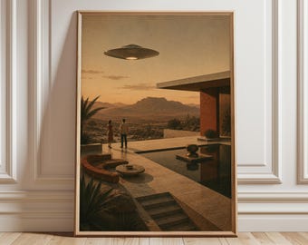 May include: A framed wall art print depicting a desert landscape at sunset with a modern house, a swimming pool, a curved sofa, and two figures standing on a patio. A metallic flying saucer hovers in the sky above the distant mountain range.