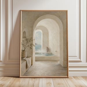May include: A framed print showing a spa scene with arched doorways leading to a pool overlooking the sea. The artwork features neutral tones, a vase with a plant, and a towel, creating a calming atmosphere.