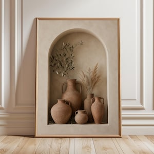 Peut inclure: Une œuvre encadrée représentant une niche aux tons neutres avec des vases en terre cuite et des plantes séchées. Les vases sont de tailles et de formes différentes, avec des anses et des surfaces texturées. L'œuvre est sur fond beige et encadrée de bois clair.