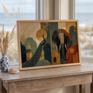 May include: A rectangular framed wall art print featuring a stylized illustration of a blue peacock and a large elephant. The artwork incorporates warm gold, deep blue, and terracotta tones with architectural elements, set in a light wood frame.