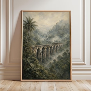 Può includere: Una stampa vintage incorniciata raffigura un ponte in pietra con più archi, un treno e una lussureggiante vegetazione tropicale. L'opera d'arte è ambientata in un paesaggio montuoso e nebbioso con palme e fitta vegetazione, incorniciata in un bordo di legno.