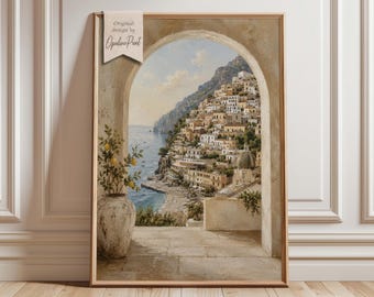 May include: A framed vertical wall art print featuring a coastal Mediterranean town built into a cliffside, viewed through a stone archway. A large ceramic pot with a lemon tree sits in the foreground. A tag reads Original design by OpalinePrint.