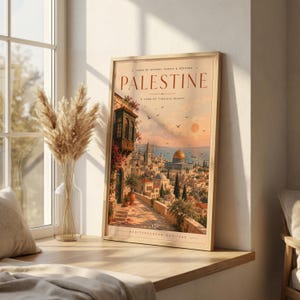 May include: A rectangular framed art print titled PALESTINE, featuring a warm-toned illustration of a historic city with stone buildings, a golden dome, and a sunset sky. The text reads LAND OF HISTORY, PEOPLE & HERITAGE and MEDITERRANEAN HERITAGE.