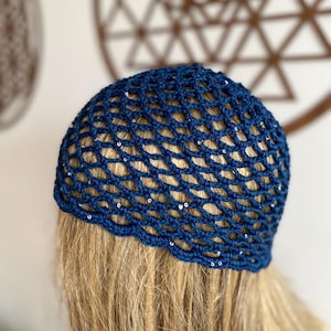 May include: A blue crochet hat with a mesh design and silver sequins.