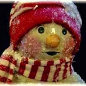 May include: A snowman with a red hat and a red and white striped scarf. The snowman has a carrot nose, green eyes, and rosy cheeks. The snowman is covered in a layer of snow.