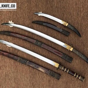 May include: Overhead view of several swords with curved blades and decorative handles. The blades are silver, and the handles feature dark wood, gold accents, and ornate metalwork. The text "BLAYDZ_KNIFE_CO" is visible in the top left corner.
