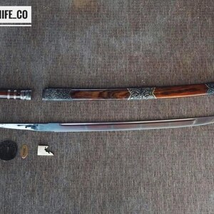 May include: A disassembled sword with a wooden handle and silver detailing. The blade is silver, and the scabbard is brown with silver accents. The text "BLAYDZ_KNIFE_CO" is in a white box in the upper left corner.