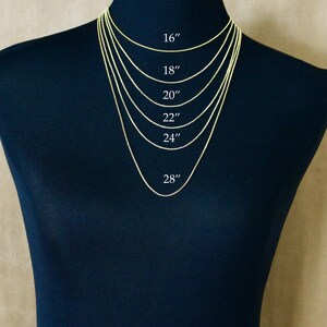 May include: A set of six gold-colored chain necklaces displayed on a dark mannequin. The chains are labeled with lengths of 16 inches, 18 inches, 20 inches, 22 inches, 24 inches, and 28 inches, showing the varying drop lengths for each necklace size.