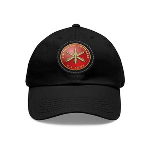 May include: Black baseball cap with a red, white, and gold embroidered patch that reads "Air Defense Artillery U.S. Army".