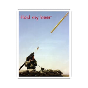 May include: A soldier in camouflage clothing is holding a weapon and looking up at a missile flying through the air. The text "Hold my beer" is written in red at the top of the image.