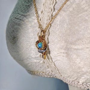 Felix Felicis lucky potion necklace displayed on a lace mannequin, illustrating its romantic and vintage aesthetic.