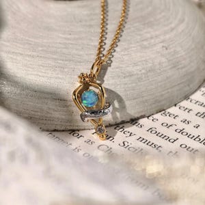 Angled view of the magical Felix Felicis opal necklace resting on a textured, off-white fabric to showcase its craftsmanship and vintage charm.