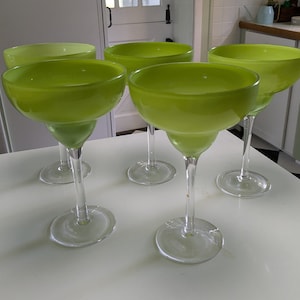 May include: Set of five lime green margarita glasses with clear glass stems and bases. The glasses are arranged on a white surface.