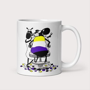 May include: White ceramic mug with a black and white illustration of two sheep. One sheep is sitting in a barber chair and has a yellow, white, and purple striped haircut. The other sheep is standing and holding scissors. The text "nakedpastor" is printed on the bottom of the mug.
