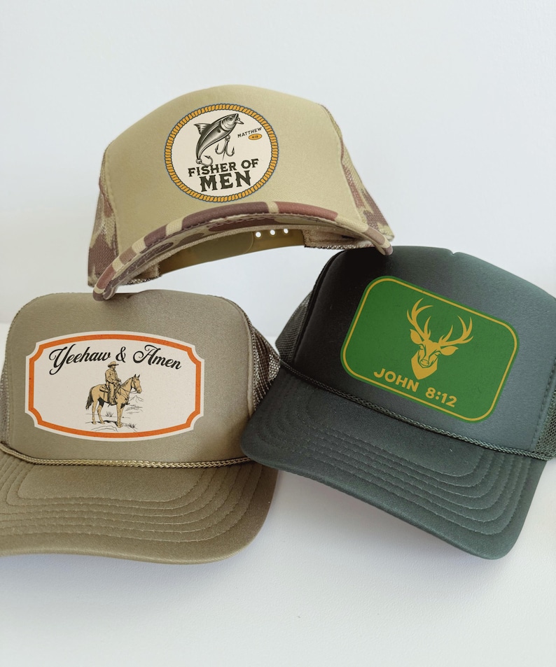Puede incluir: Tres gorras de camionero con diferentes dise&ntilde;os. Una gorra es de color beige con un patr&oacute;n de camuflaje y un parche circular que dice "FISHER OF MEN". Otra gorra es de color verde oliva con un parche que dice "Yeehaw & Amen". La tercera gorra es de color verde oscuro con un parche verde que dice "JOHN 8:12".