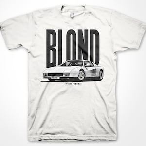 May include: White t-shirt with a black graphic of a white Ferrari Testarossa with the word "BLOND" in large black letters above the car and the words "WHITE FERRARI" below the car.